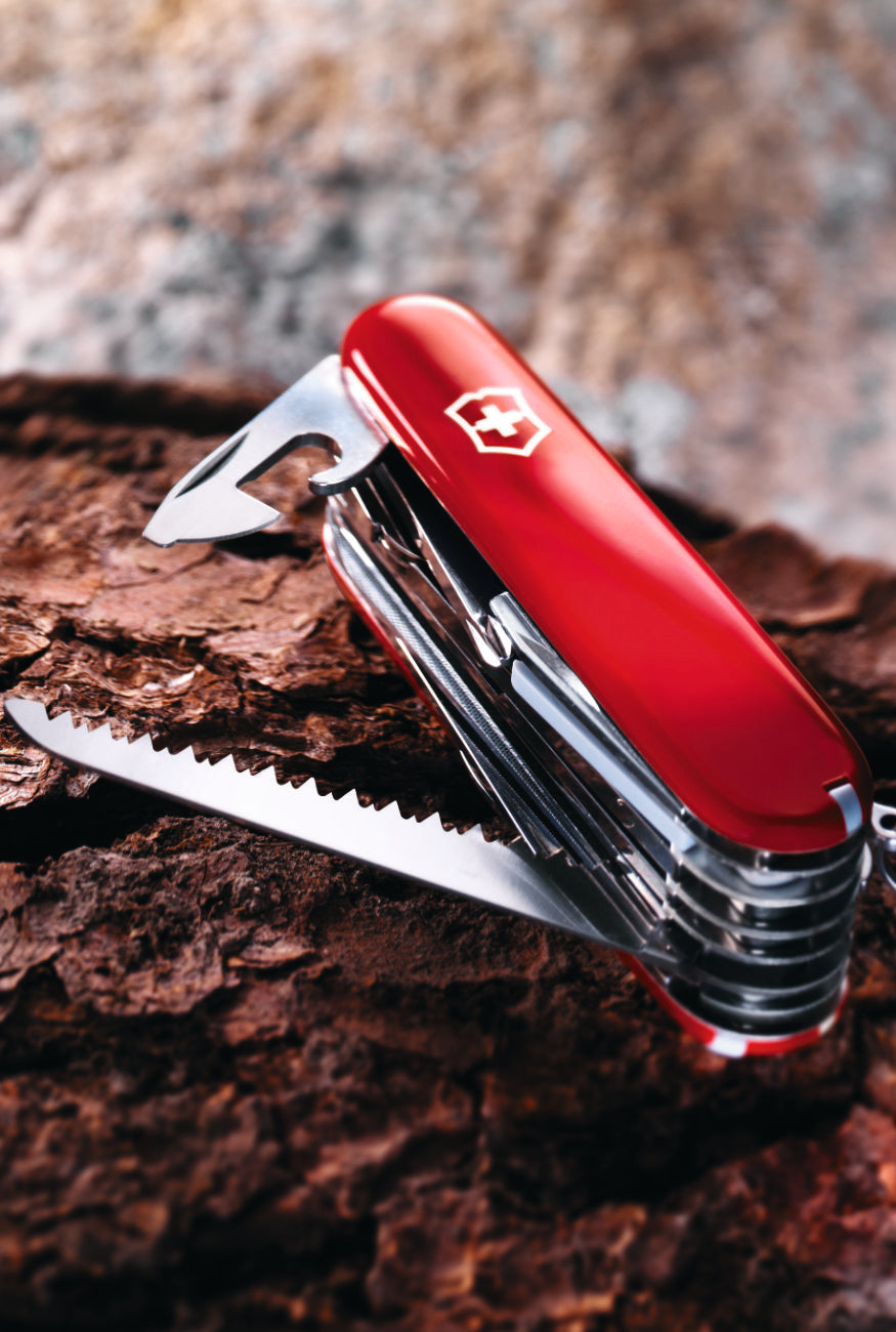 Red Swiss Army knife on a wooden surface