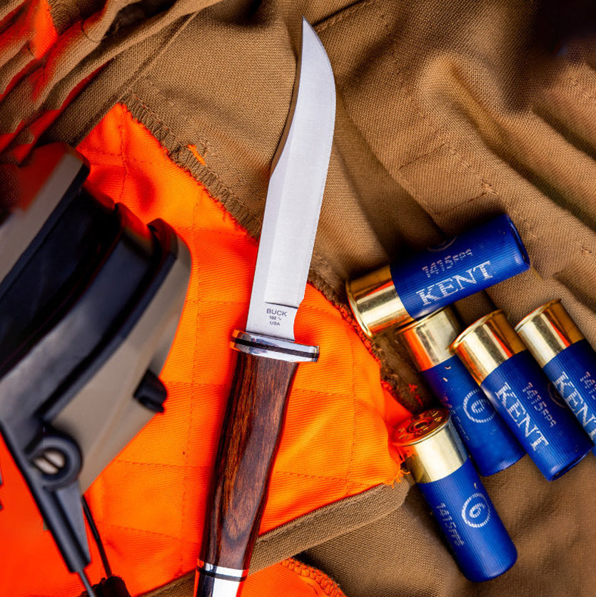 Knife and shotgun shells on orange and brown fabric