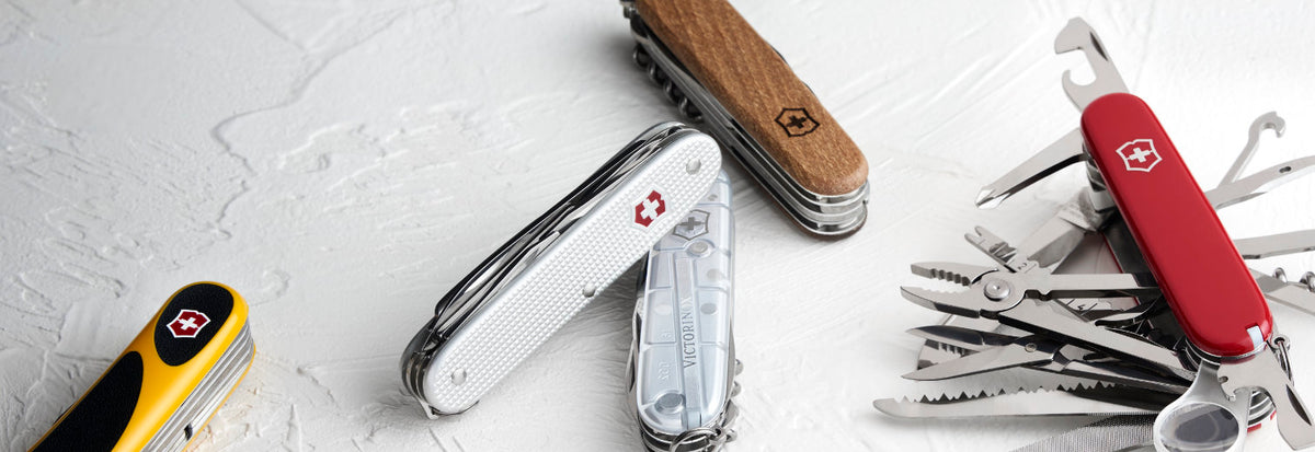 Collection of Swiss Army knives on a light gray background