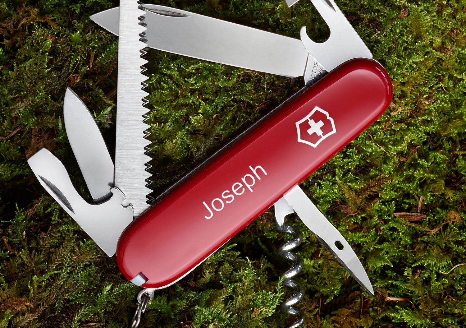 Swiss army knife with the name Joseph on moss background