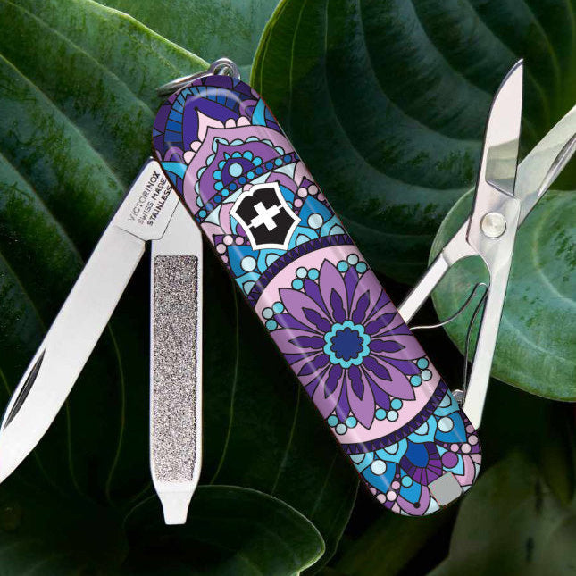 Multitool with purple and blue mandala design on a green leaf background