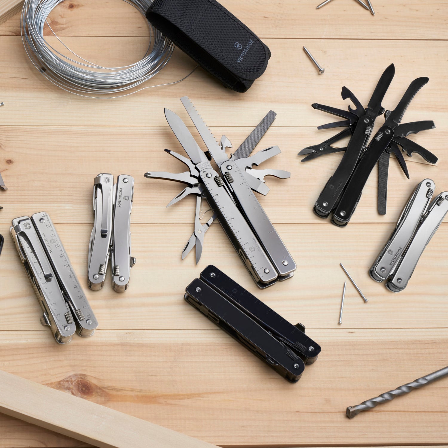 Multiple Swiss Army Knives on wooden table
